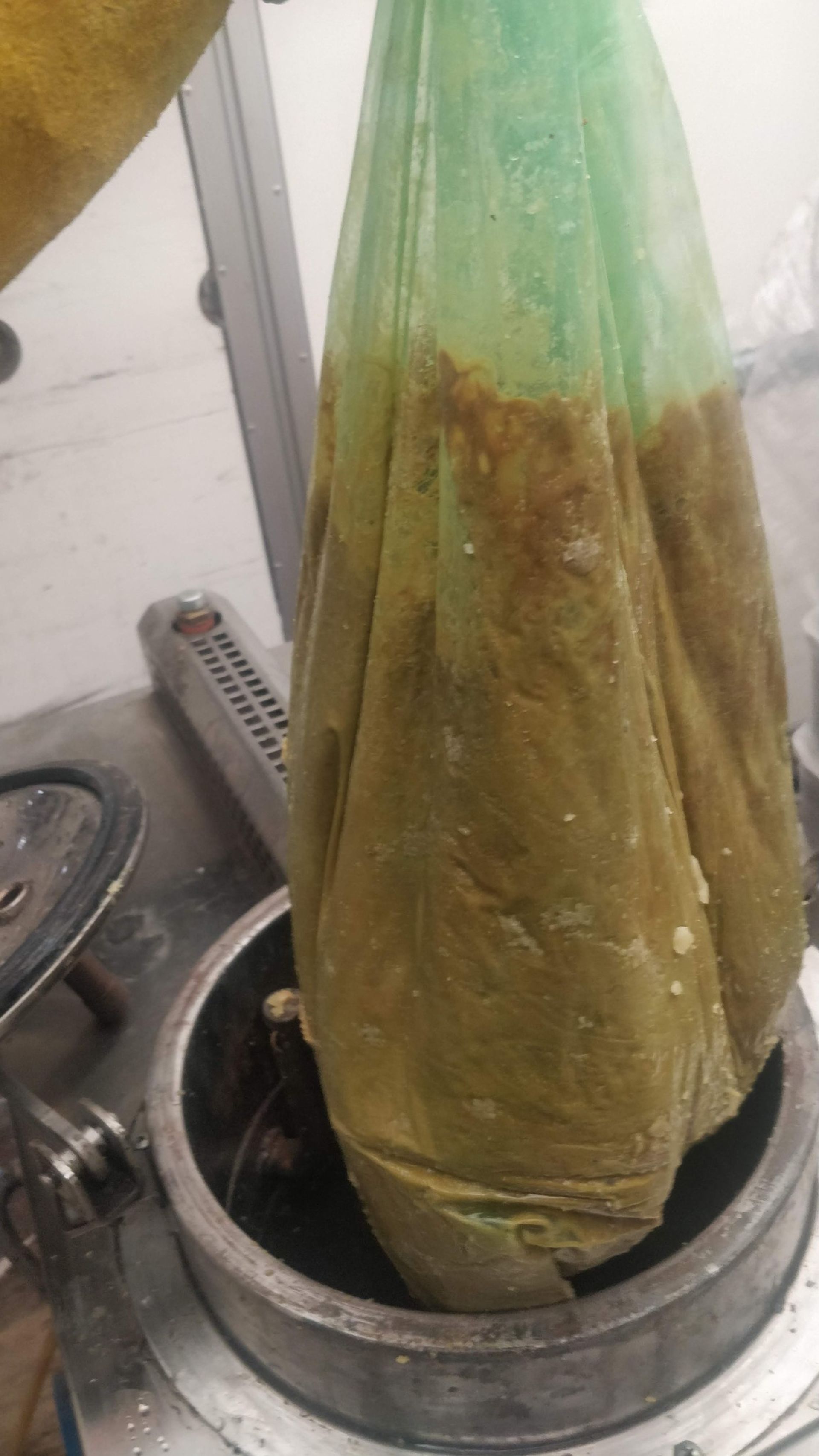 Una bolsa verde con una tapa verde sobre una olla de metal